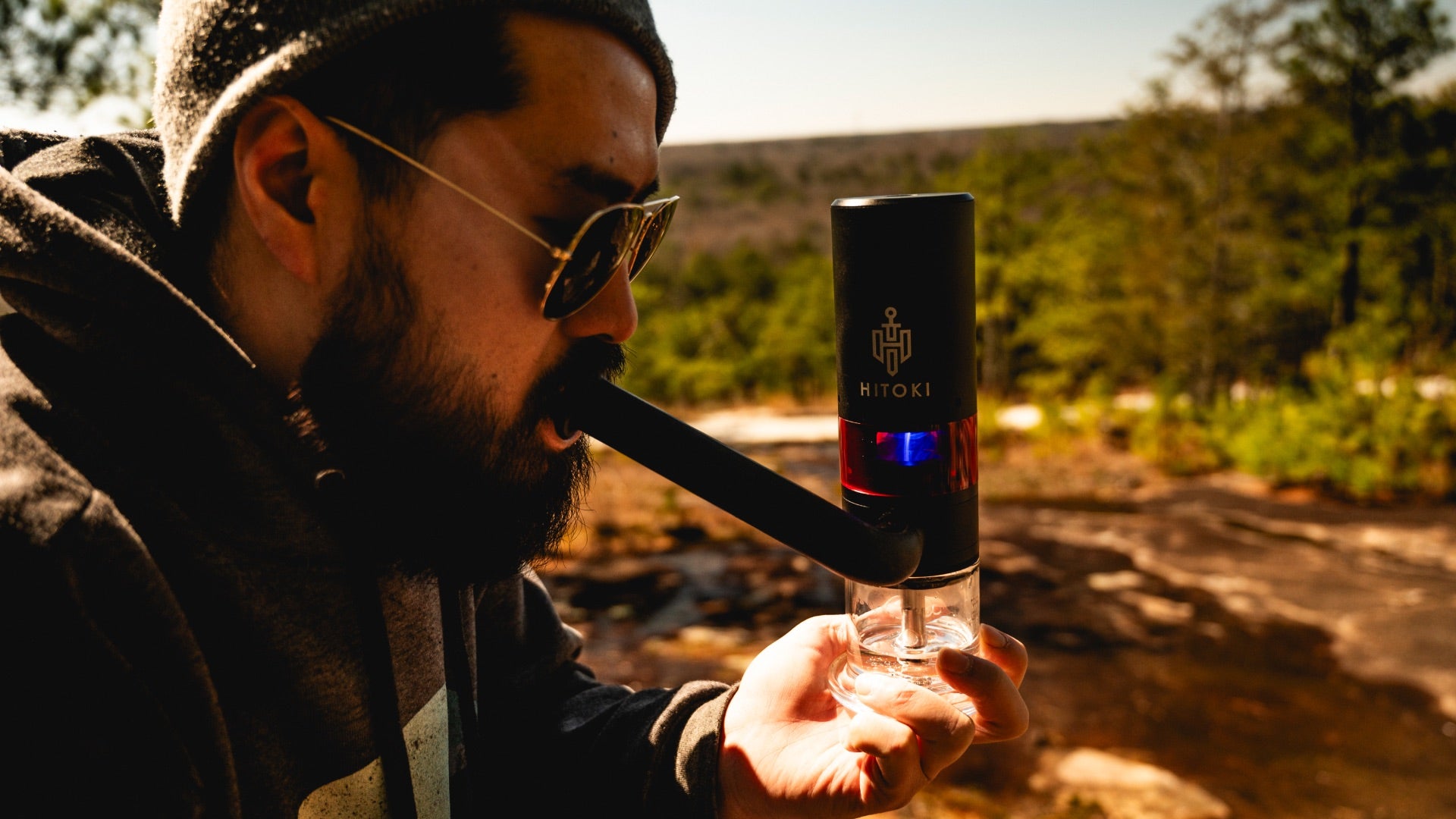 Person using Hitoki Trident V3, showing windproof laser ignition outdoors